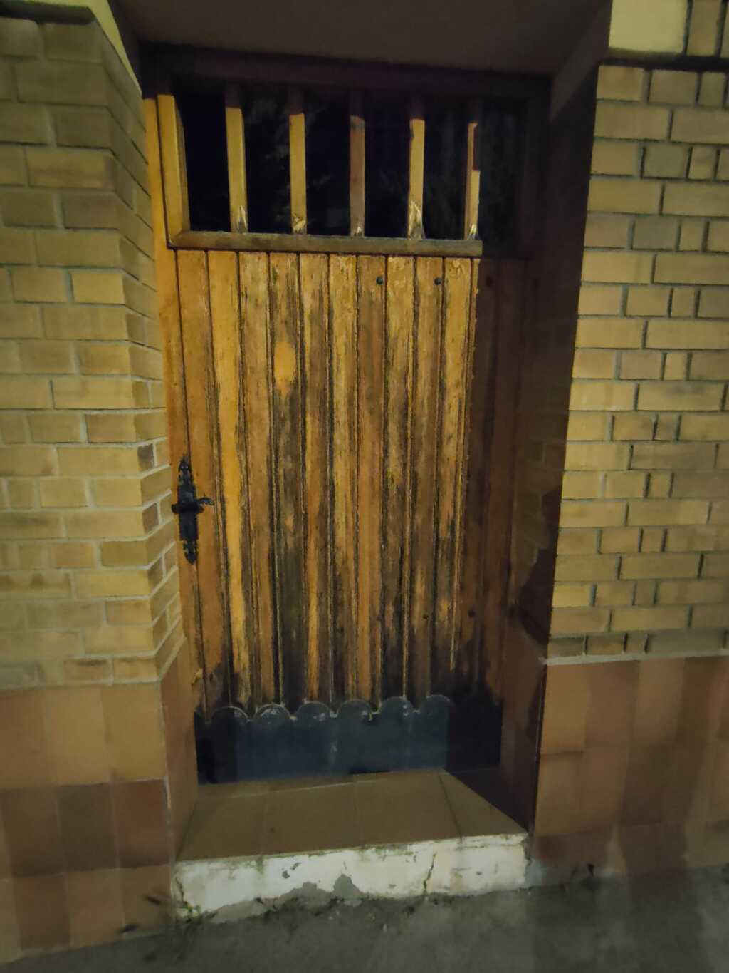 Detalle de la puerta de entrada de madera deteriorada por el tiempo - Topi Lleida