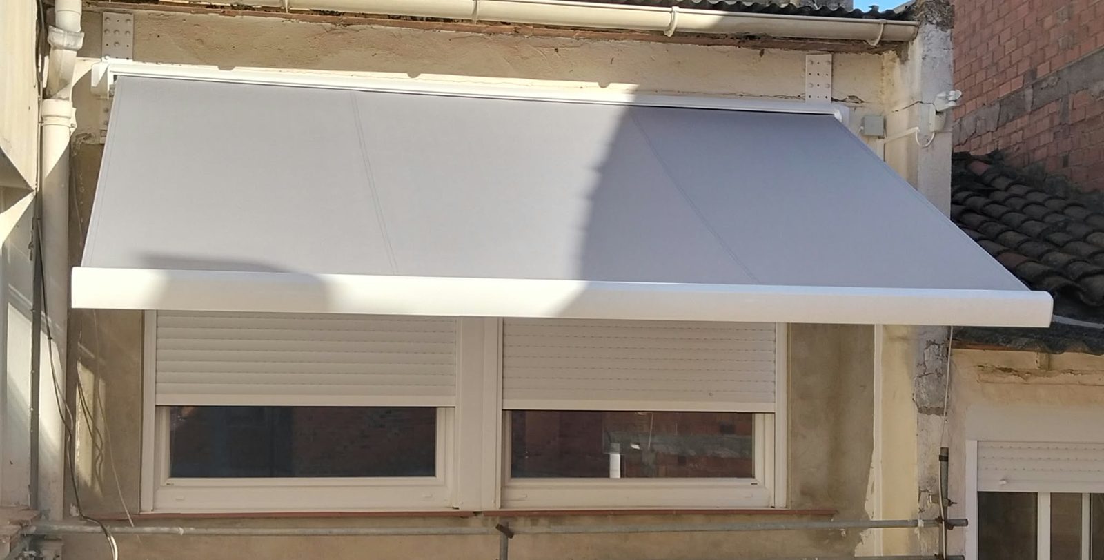 Toldo cofre motorizado con sensor de viento instalado en la fachada de una vivienda en Lleida